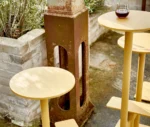 Close-up of Bla Station Combo stools and tables in yellow finish in outside setting.