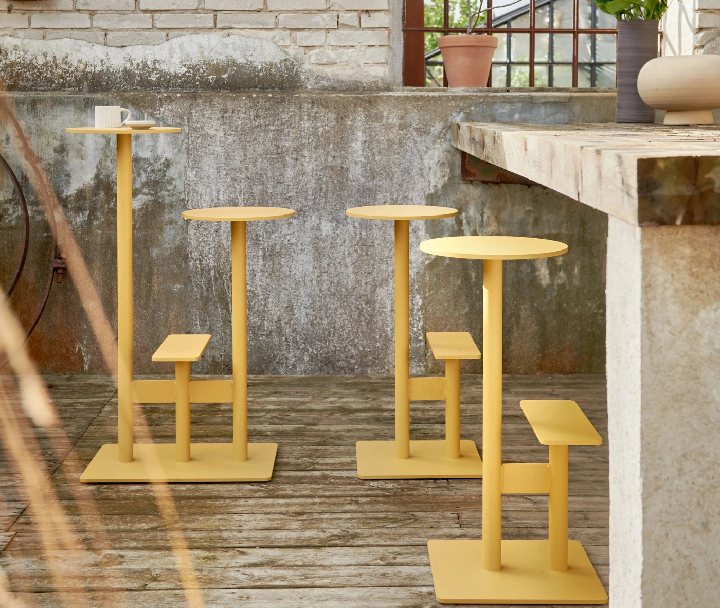 Bla Station Combo stools and tables in yellow finish in outside setting.