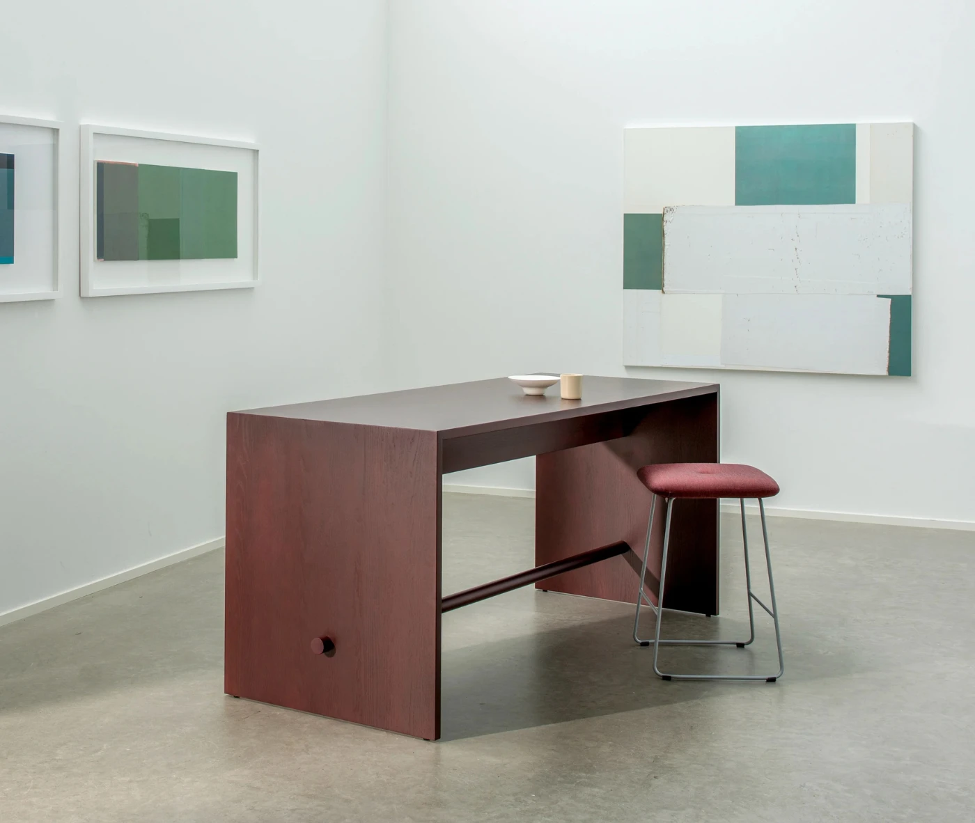 Bla Station Dundra Barstool in a studio setting with a red upholstered seat and slim steel base.