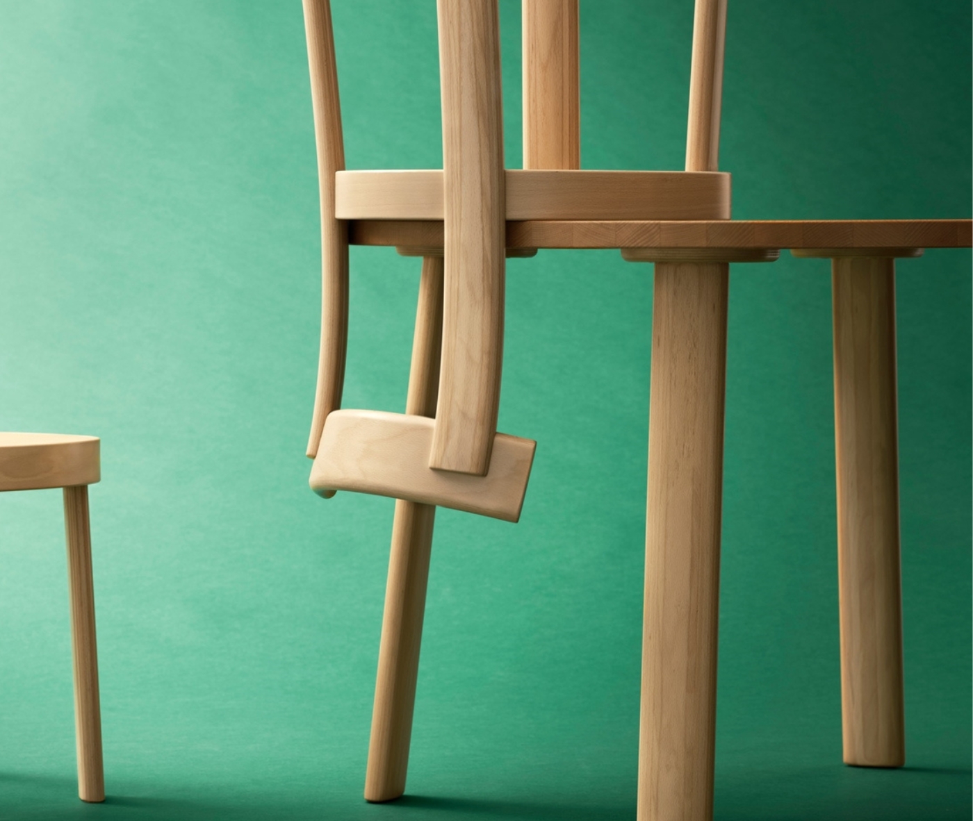 Bla Station Frankfurter chair hooked onto a matching timber table in a studio setting.
