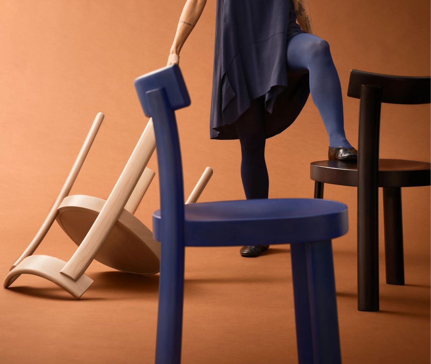 Bla Station Frankfurter chairs in different timber finishes with a person in a studio setting.