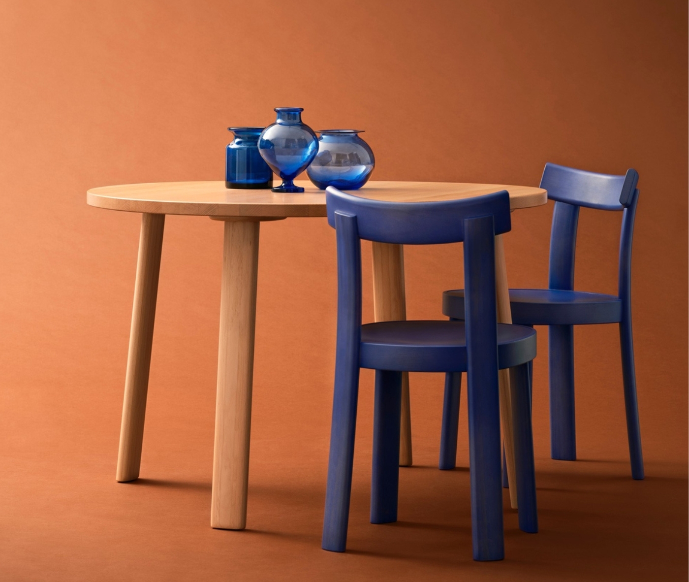 Bla Station Frankfurter blue timber chairs with a natural timber table in a studio setting.