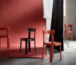 Bla Station Frankfurter red and black timber chairs with a natural timber table in a studio setting.