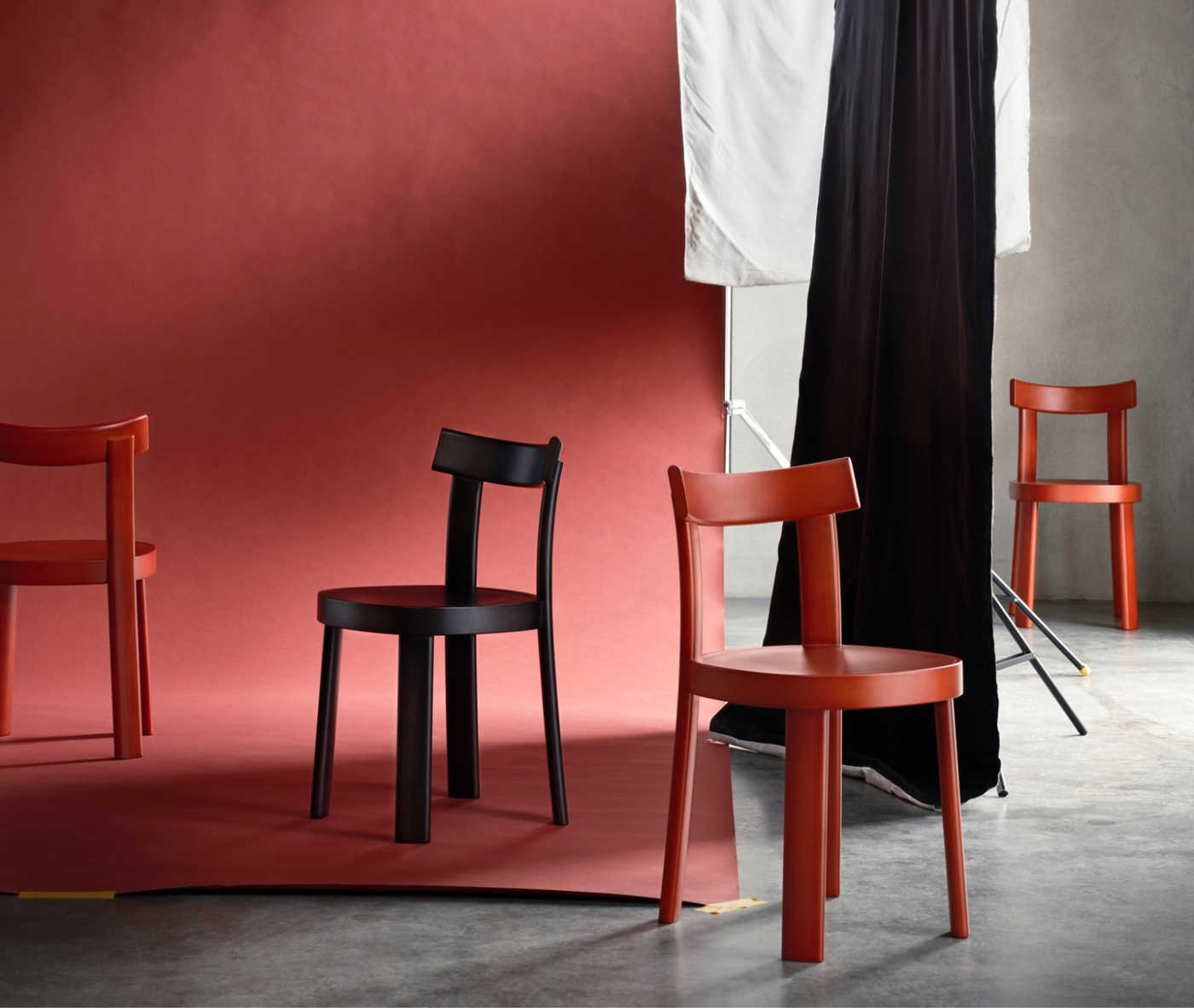 Bla Station Frankfurter red and black timber chairs with a natural timber table in a studio setting.
