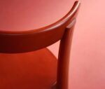 Close-up of Bla Station Frankfurter chair with curved backrest and red timber.