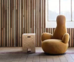Bla Station Oppo lounge chair in a lounge setting with yellow upholstery and a sculptural form.