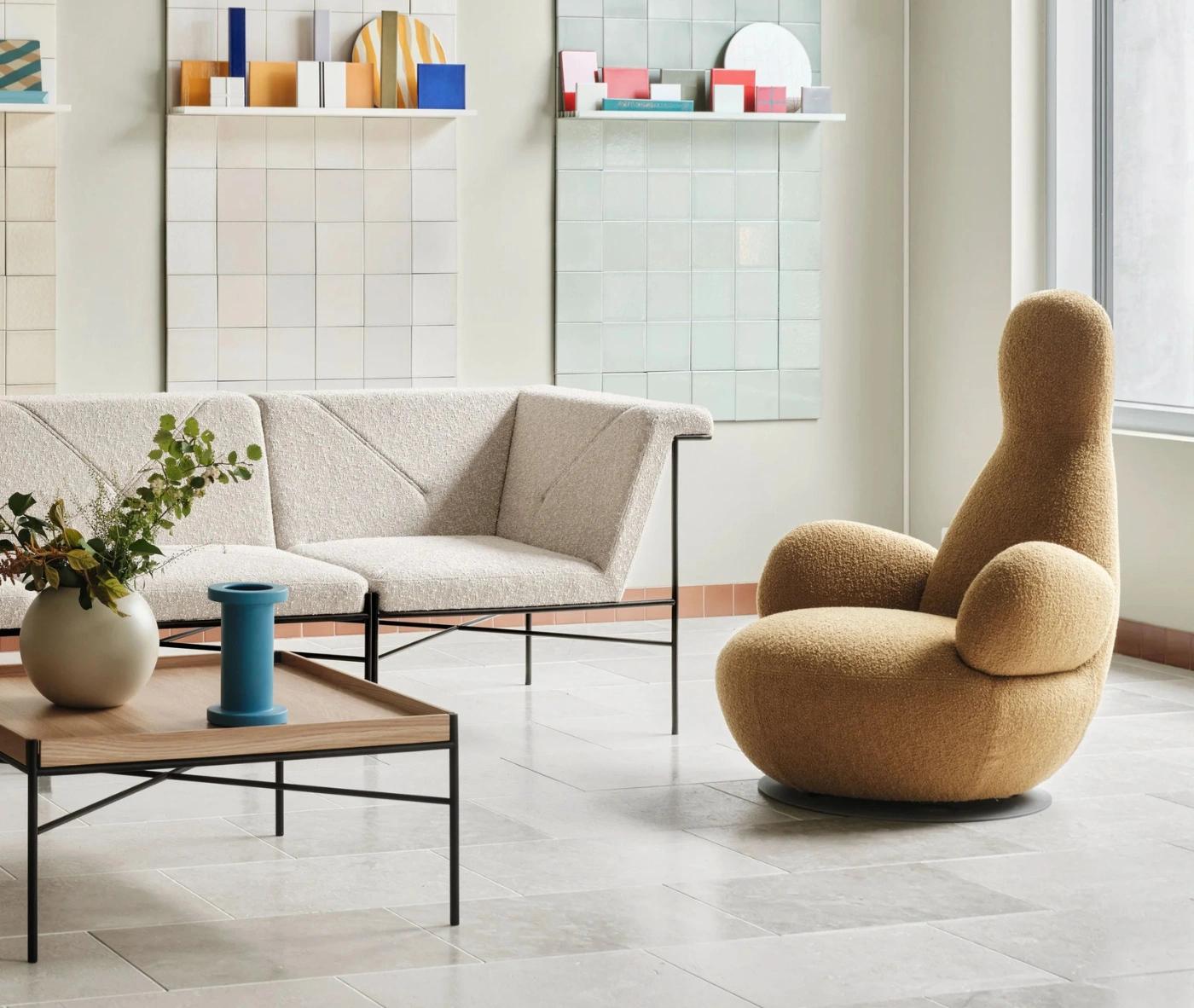 Bla Station Oppo lounge chair in a lounge setting with fully upholstered mustard yellow fabric and a high rounded back.