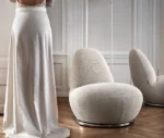 Bla Station Oppo lounge chair in a lounge setting with fully upholstered white fabric and a rounded sculptural design.