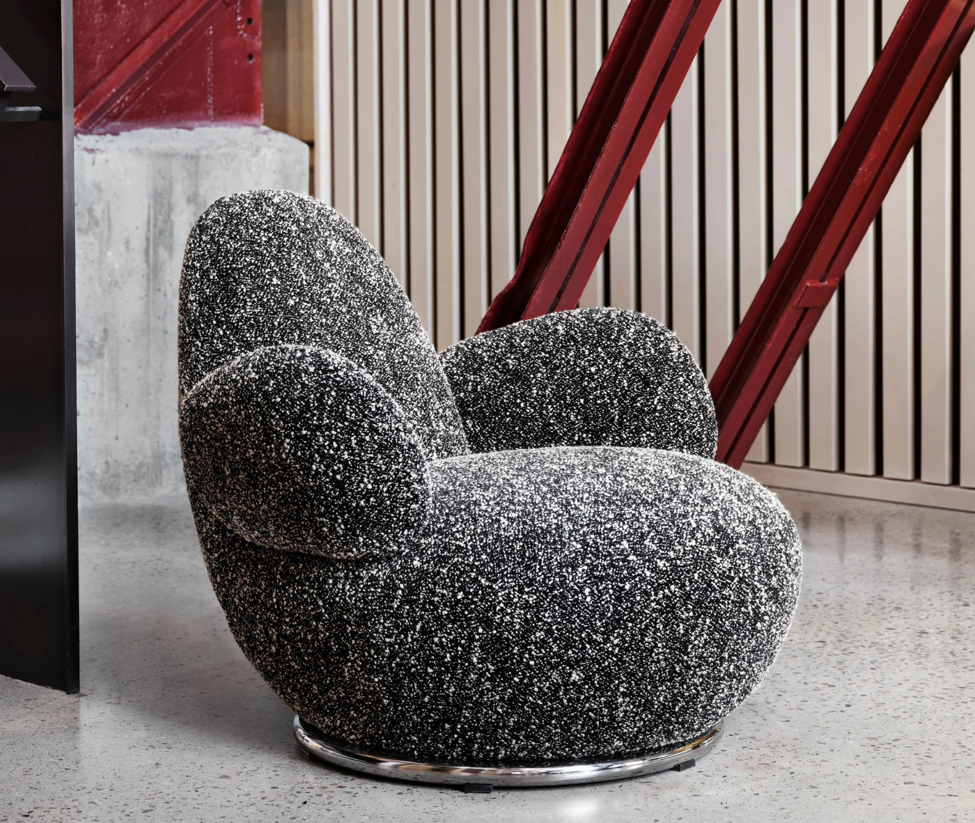 Bla Station Oppo lounge chair in a lounge setting with black-and-white speckled upholstery.