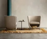 Bla Station Pocket lounge chairs in cream upholstery with cocoon-like design and open storage space beneath the seat.