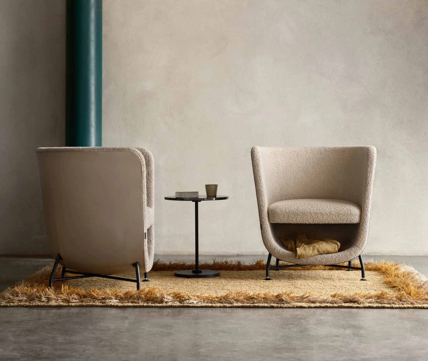 Bla Station Pocket lounge chairs in cream upholstery with cocoon-like design and open storage space beneath the seat.