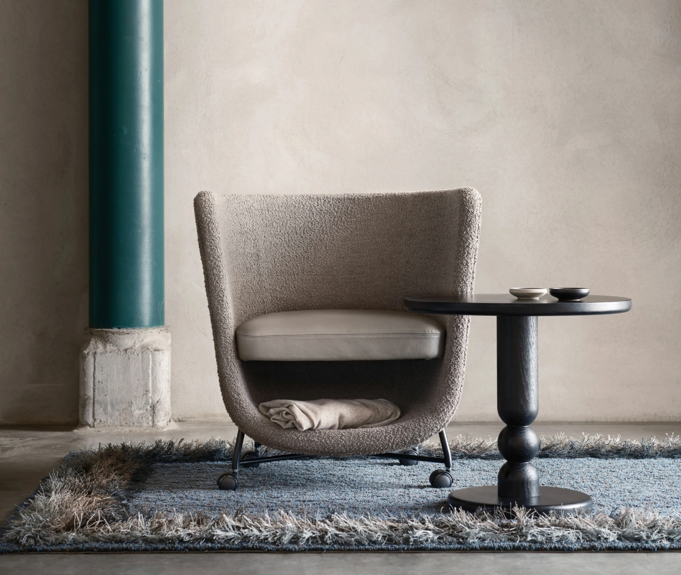Bla Station Pocket lounge chair with cocoon-like upholstered design and under-seat storage.