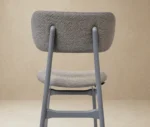 P4 Annalisa C2 hospitality chair in back view, in studio setting, grey upholstered seat, and timber frame.