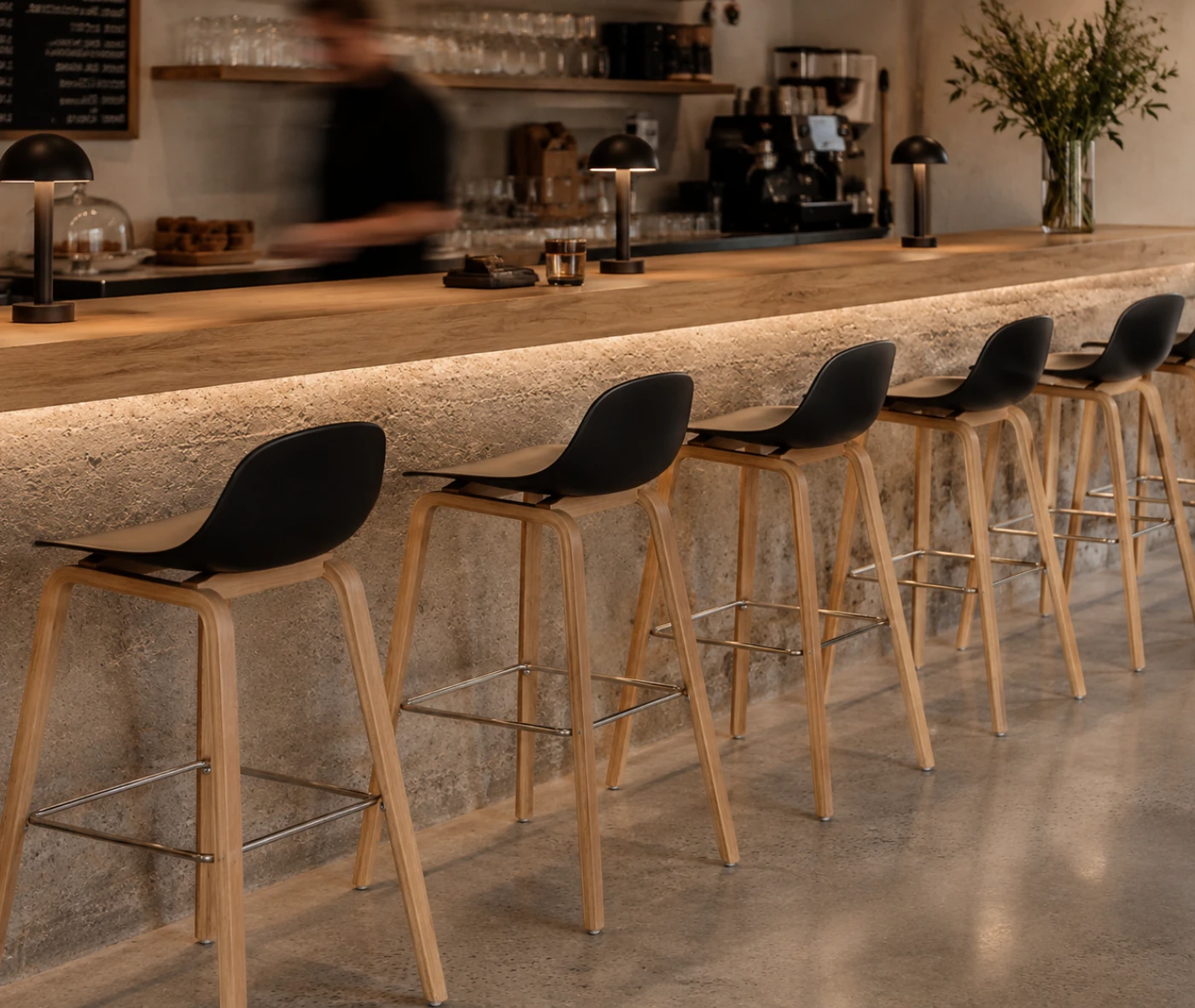 P4 Loop Mini stools lined up in hospitality setting with backrests and natural timber legs.