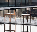 True Adinne chairs in outdoor setting with timber finishes and leather backrests.