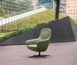 True Ahkka lounge chair in outdoor setting with soft upholstered curves and a swivel base.