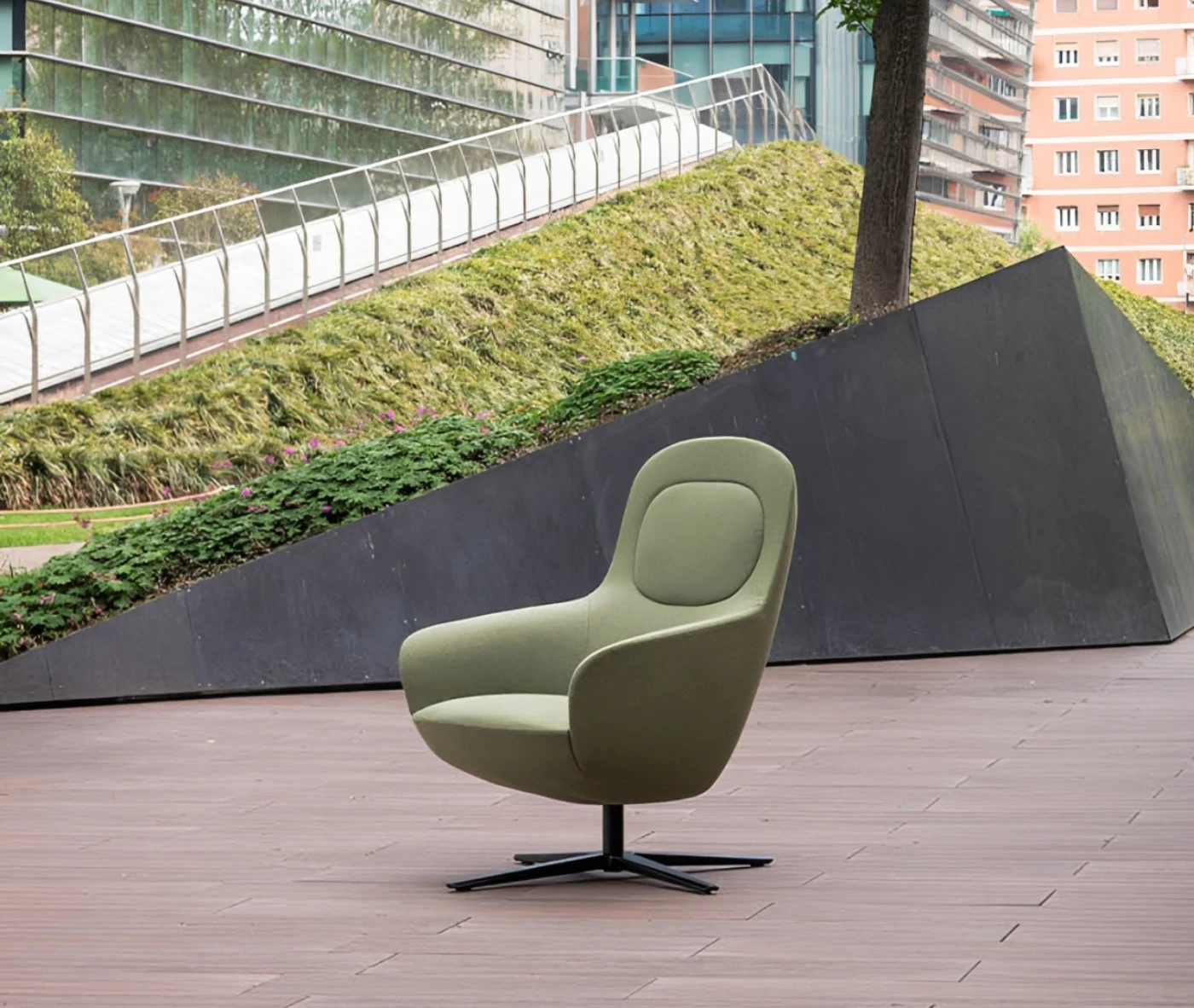 True Ahkka lounge chair in outdoor setting with soft upholstered curves and a swivel base.