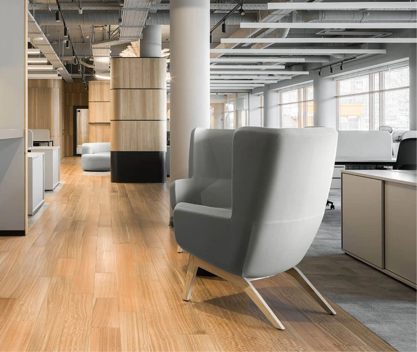 True Arca high-back lounge chair in an office setting with high grey upholstered backrest, seat pad, and timber legs.