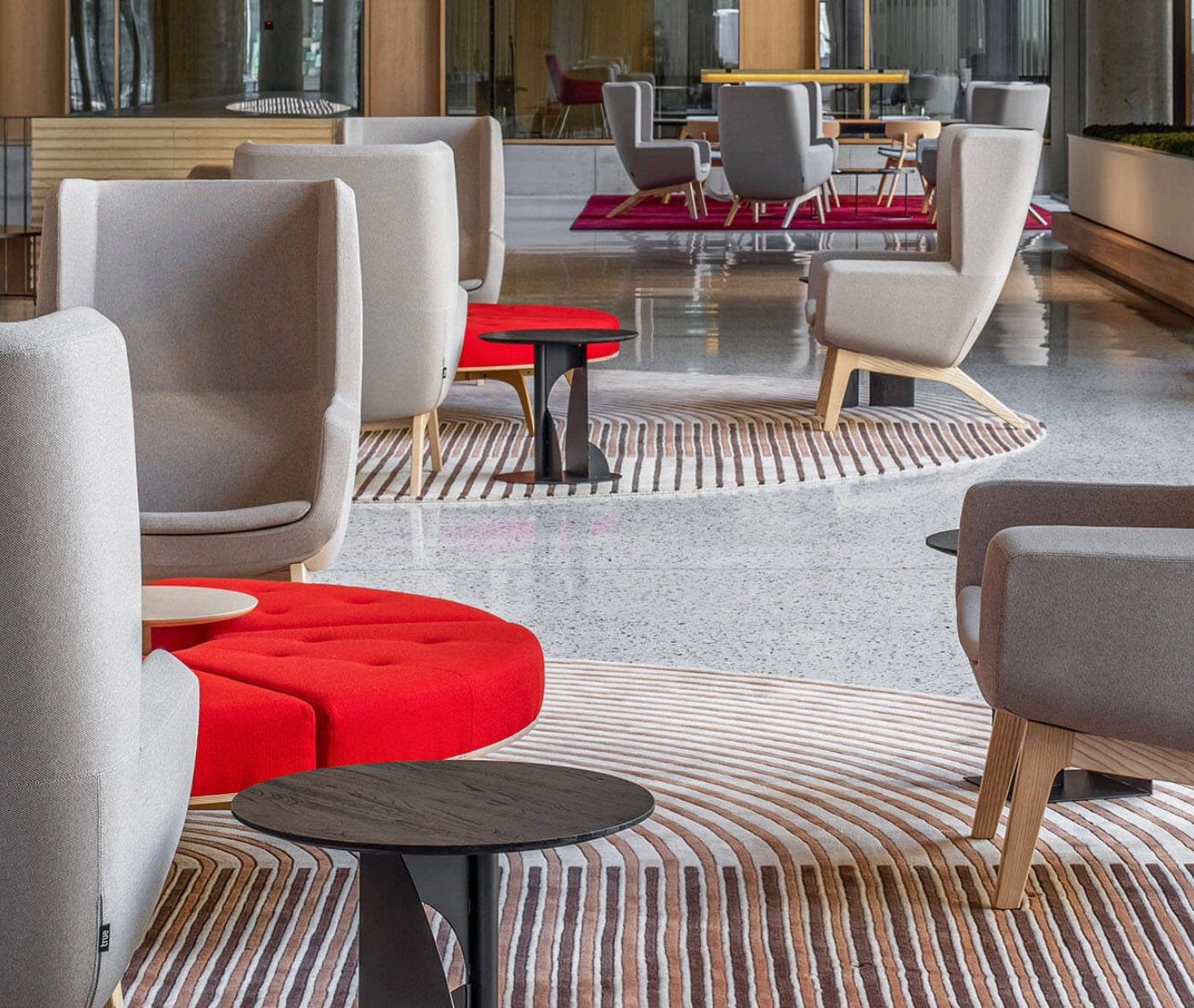 True Arca high-back chair in a lobby setting with high grey upholstered backrest, seat pad, and timber legs.