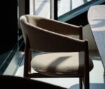 True Aura lounge chair in hospitality setting with wraparound backrest and upholstered seat.