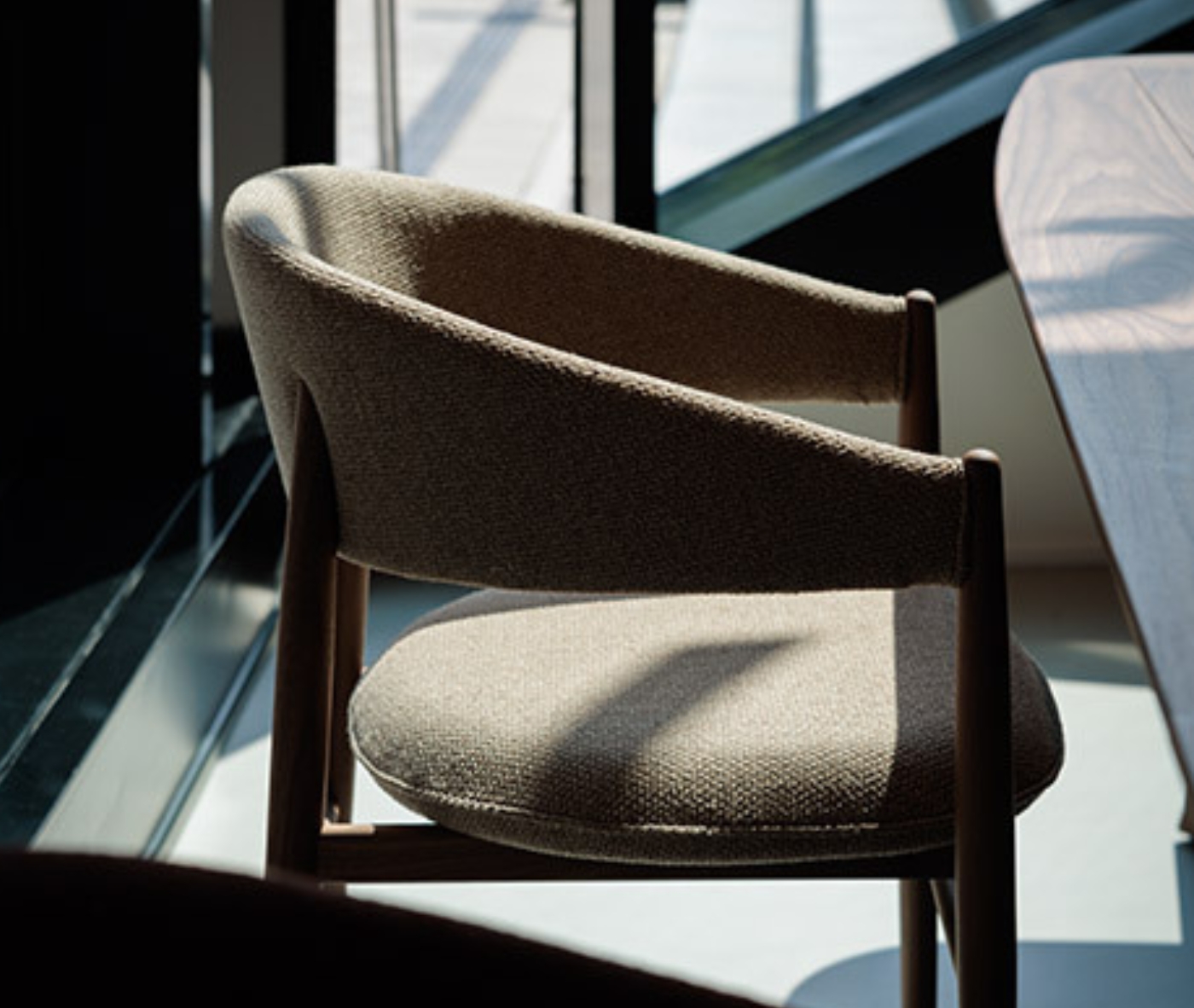 True Aura lounge chair in hospitality setting with wraparound backrest and upholstered seat.