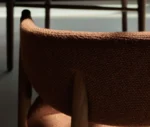 Close-up of True Aura in meeting setting with upholstered backrest and seat, and timber frame.