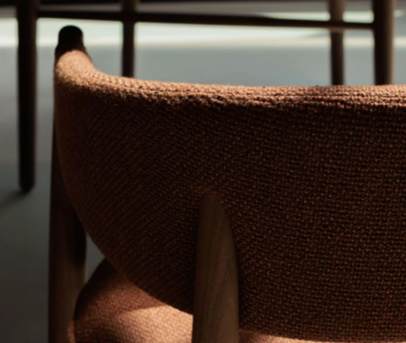 Close-up of True Aura in meeting setting with upholstered backrest and seat, and timber frame.