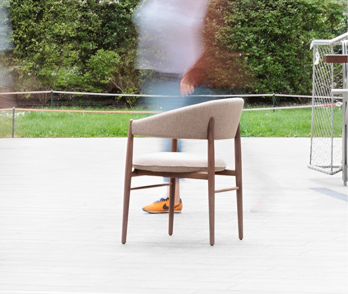 True Aura lounge chair in outdoor setting with wraparound backrest and upholstered seat.