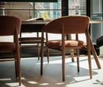 True Aura chairs in meeting setting with wraparound upholstered backrests and timber frames.