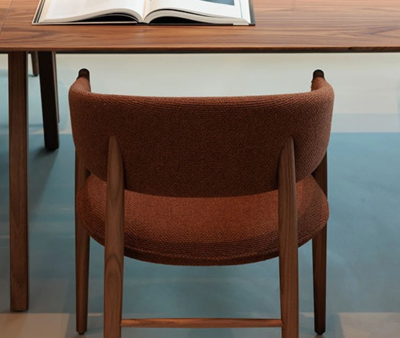True Aura chair in workspace setting with wraparound upholstered backrest.