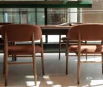 True Aura chairs in meeting setting with upholstered backrests and timber frames.