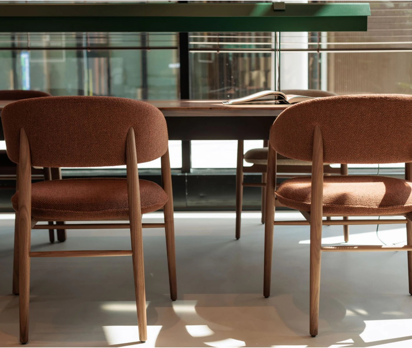True Aura chairs in meeting setting with upholstered backrests and timber frames.