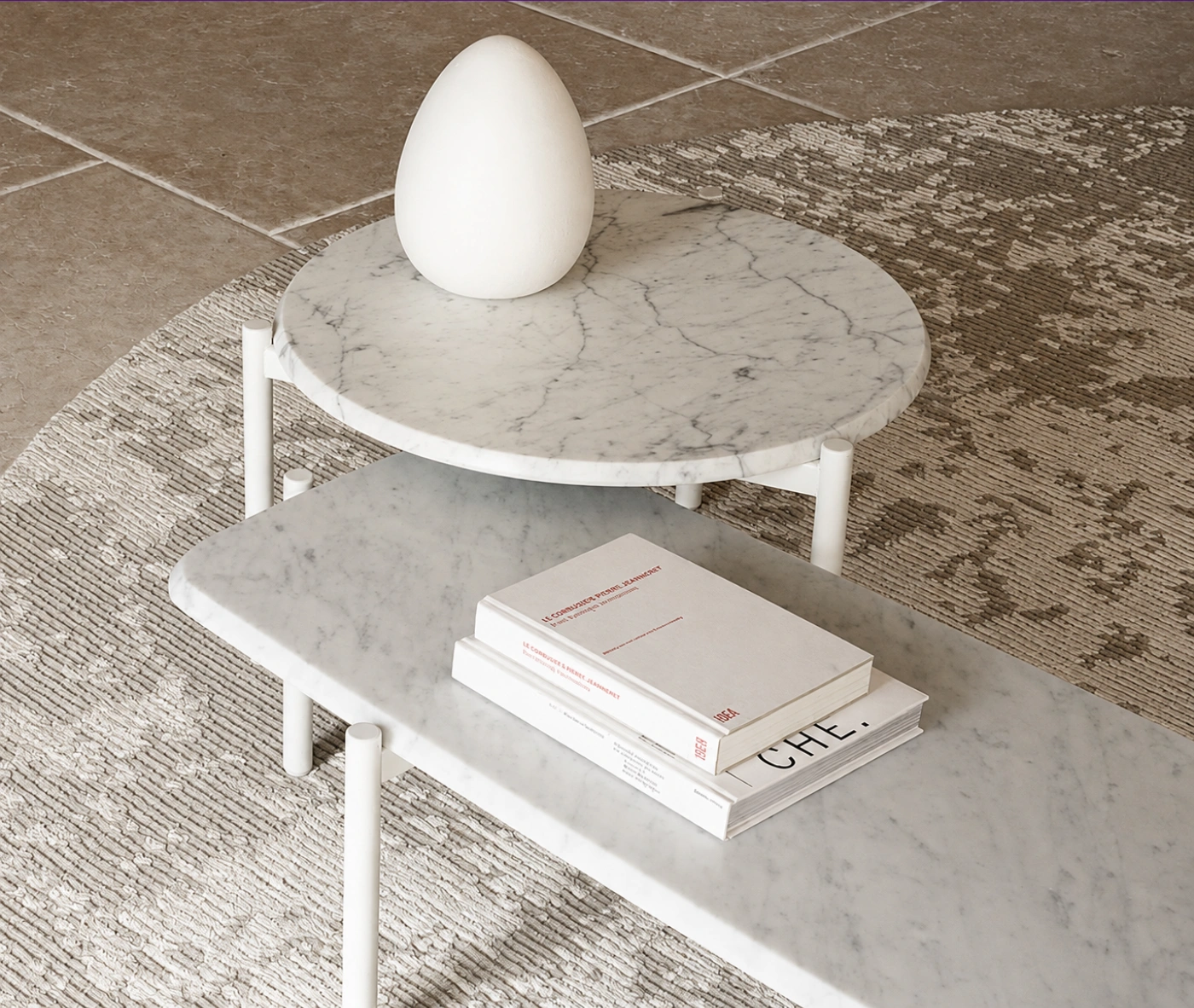 True Blade coffee tables arranged as a set with white marble tabletops and slim metal legs in a lounge setting.