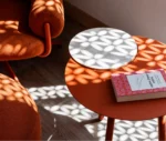 True Cloud round table with a red finish and removable timber tray in a lounge setting.