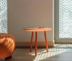 True Cloud round table with a red finish and removable timber tray in a lounge setting.