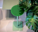 True Cremino table in showroom setting with layered round glass tabletop in green finish.