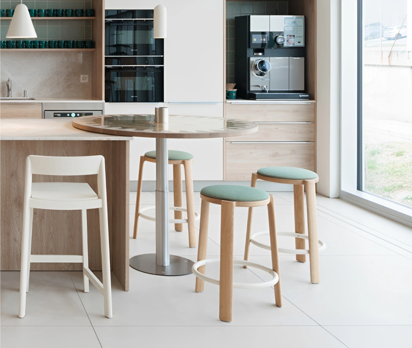True Cute stools with green upholstered seat, timber legs, circular footrest in a kitchen setting.