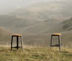 True Cute stools with mustard yellow upholstered seats, timber legs, circular footrest in an outdoor setting.