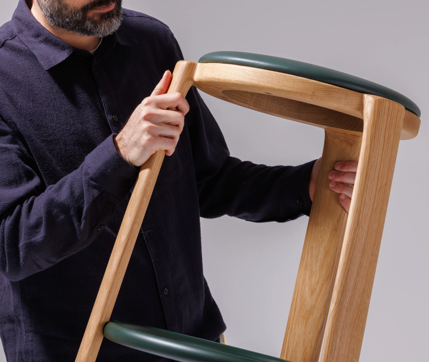 Close-up of the True Cute stool, highlighting its upholstered seat and timber frame.