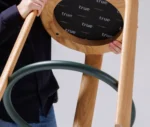 Close-up of the True Cute stool, highlighting its upholstered circular footrest and timber legs.