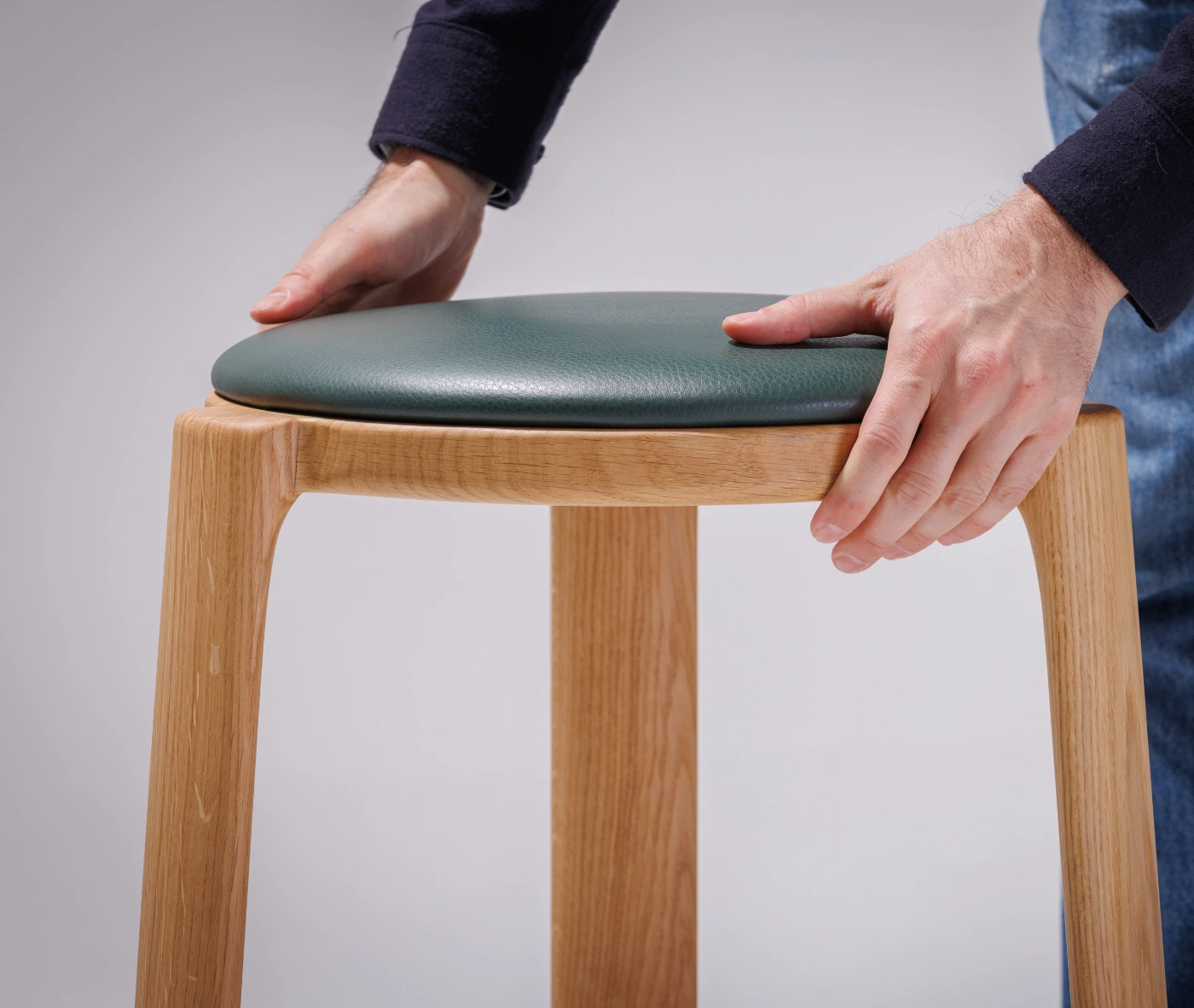 Close-up of the True Cute stool, highlighting its upholstered seat and timber frame.