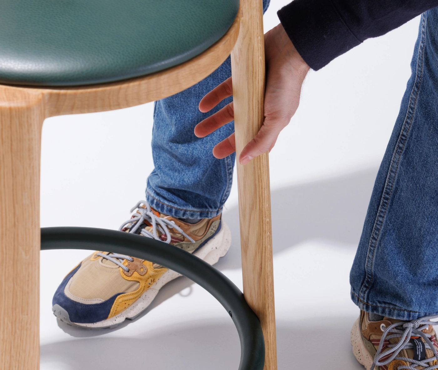 Close-up of the True Cute stool, highlighting its timber legs and circular footrest.
