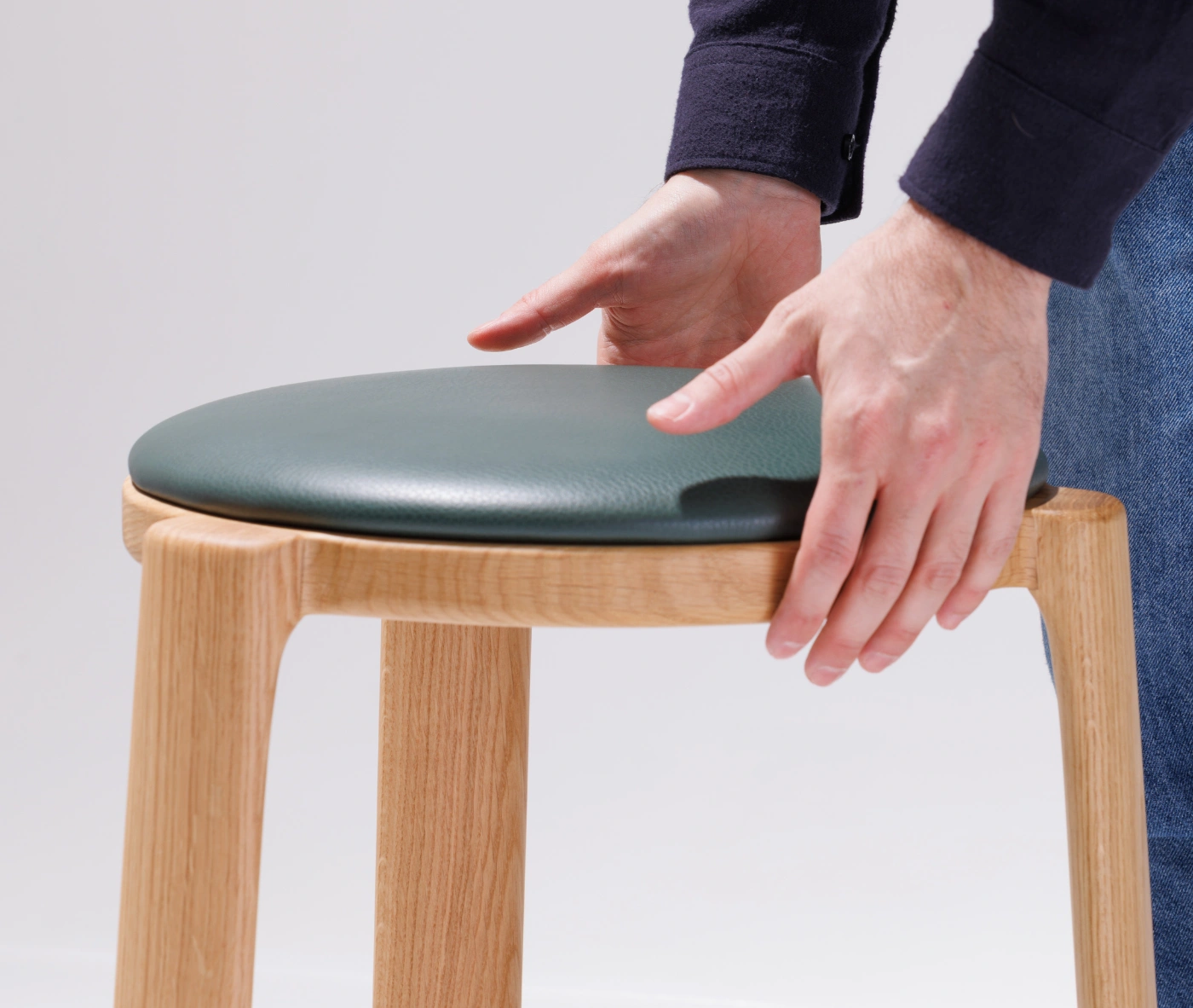 Close-up of the True Cute stool, highlighting its upholstered seat and timber frame.