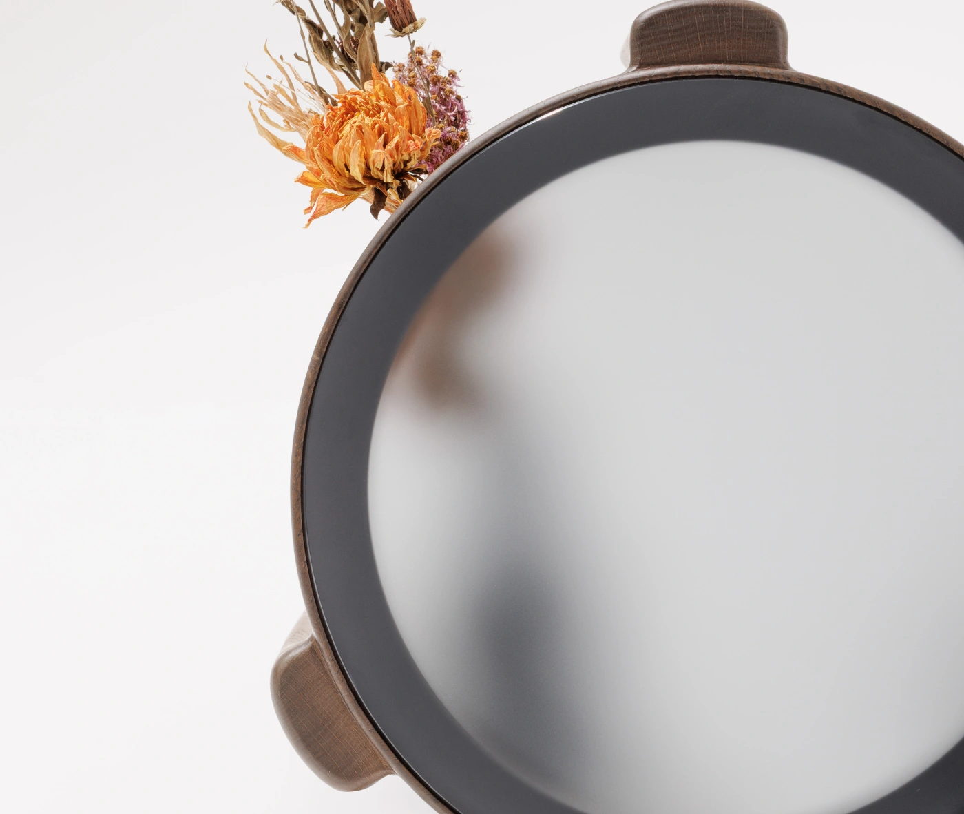 True Cute top view of round occasional table with glass top and timber legs in a studio setting.