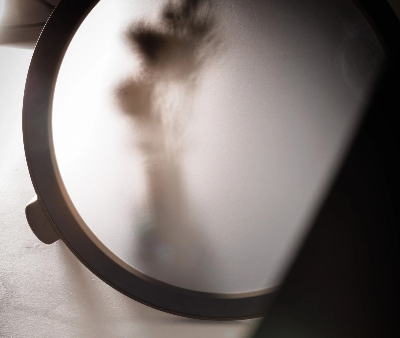 True Cute close-up view of round glass tabletop and solid timber frame.