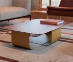 True Fiocco table in lounge setting with soft-edged rectangular top and short curved metal base.