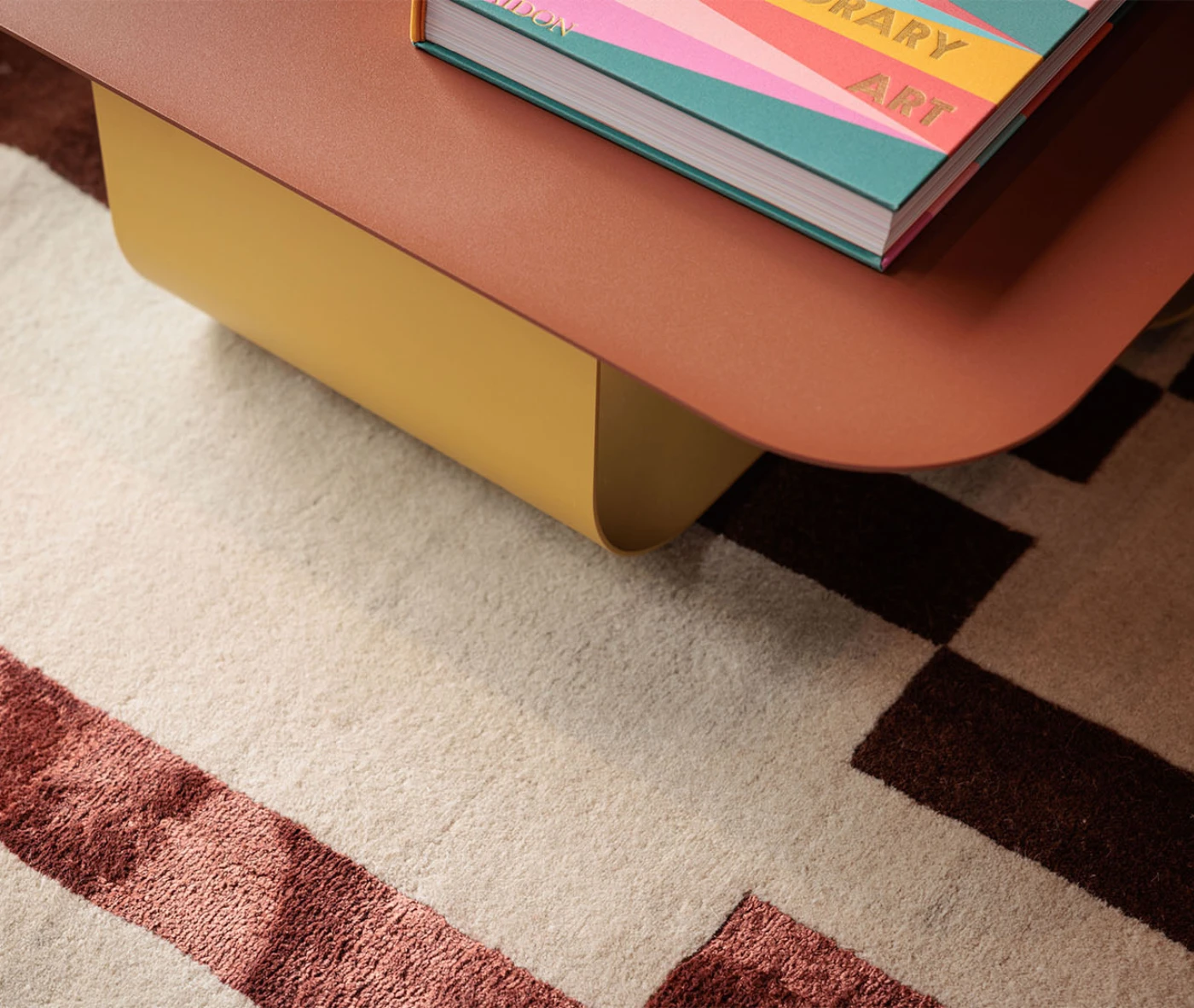 Detail of True Fiocco table in studio setting highlighting the soft edges and curved metal base.