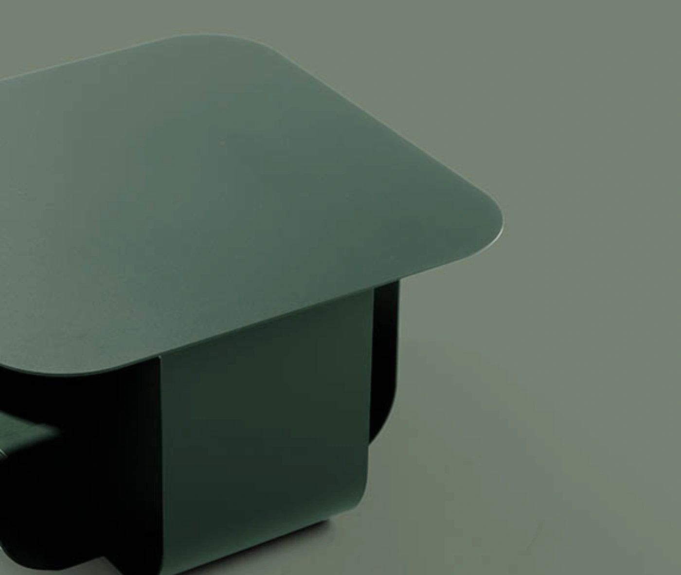 True Fiocco table close-up in studio setting with soft-edged square top and short curved metal base.