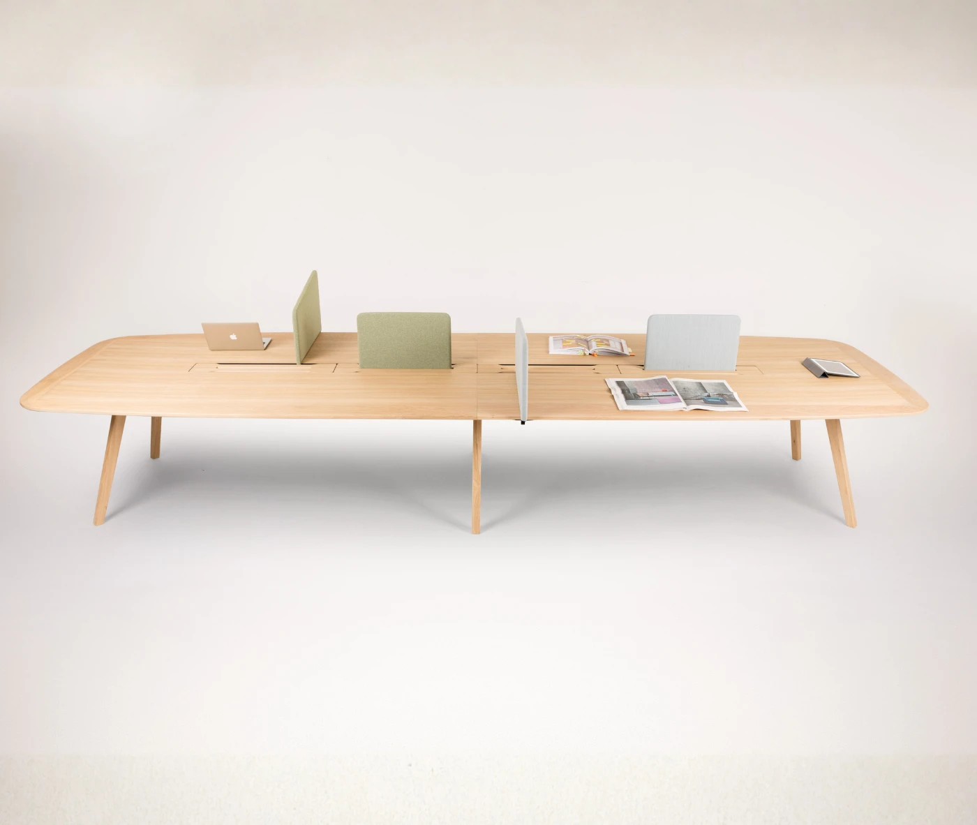 True Wing Working table in front view with light timber top and frame, padded divider screens, and workspace accessories.