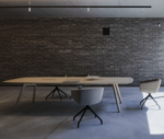 True Wing table in a meeting setting with a light timber tabletop and timber legs, surrounded by Arca chairs.